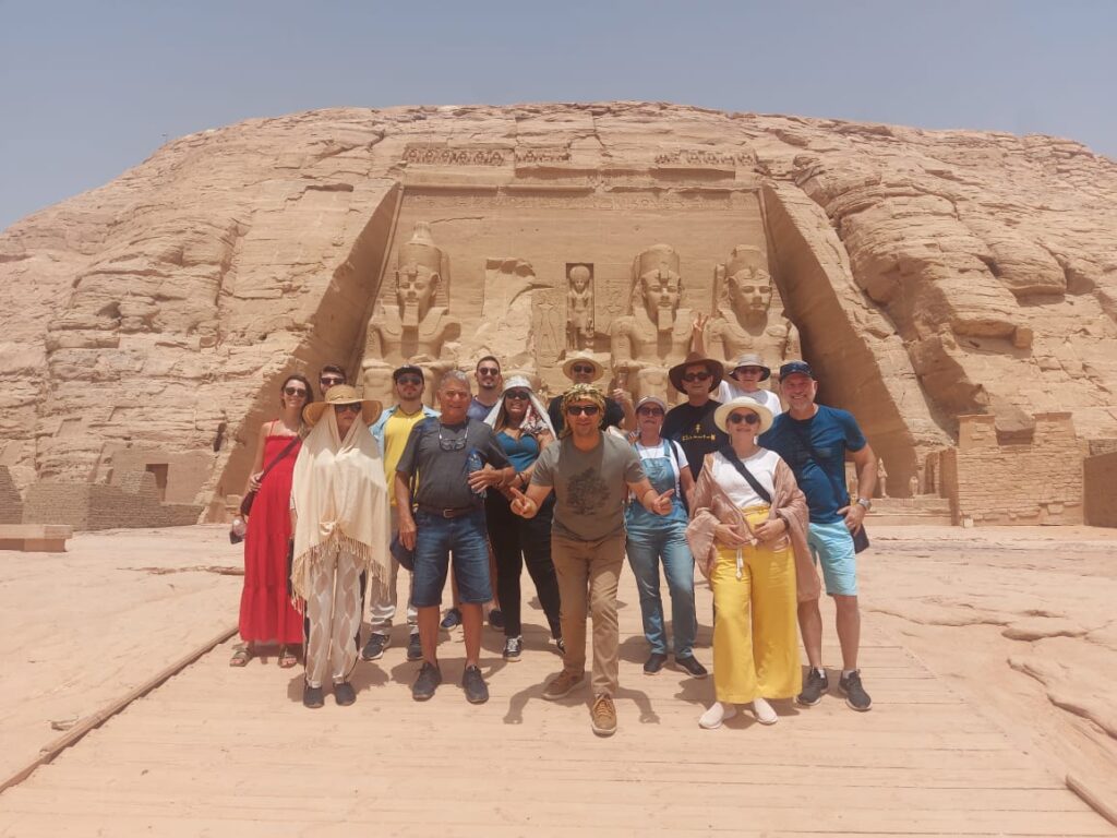 Grupo de viajantes da Girotrip em frente ao grandioso Templo de Abu Simbel, no sul do Egito, uma experiência histórica em uma viagem em grupo.