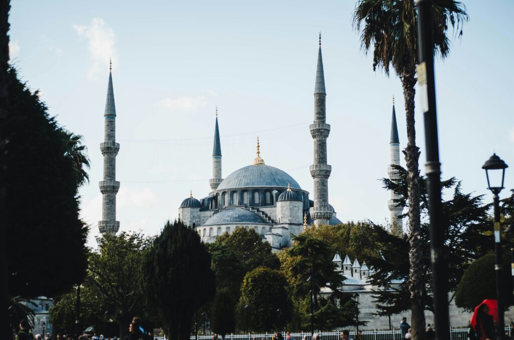 Mesquita Azul em Istambul, com suas cúpulas e minaretes, iluminada ao anoitecer, um ponto turístico imperdível para quem quer visitar a Turquia em uma viagem em grupo.